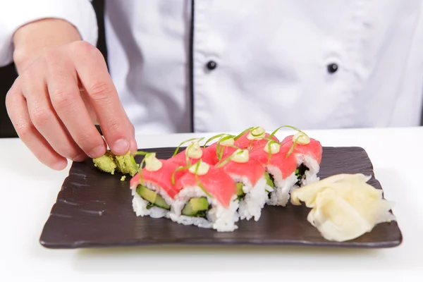 Cook ajoute du wasabi et du gingembre aux rouleaux de sushi — Photo