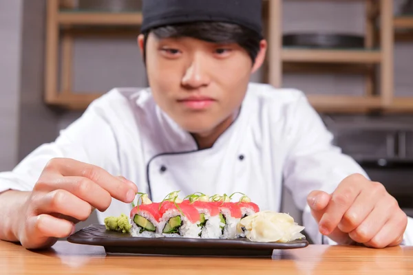 Cook puts seaweed on sushi — Stock Photo, Image