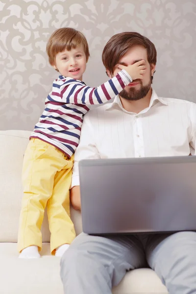 Homem e menino usam laptop — Fotografia de Stock