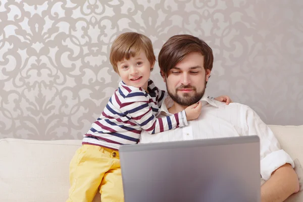 Homem e menino usam laptop — Fotografia de Stock