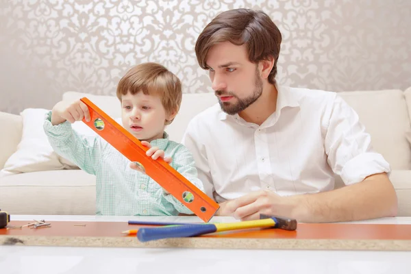 Father and son play with a toy building kit — Stock Photo, Image