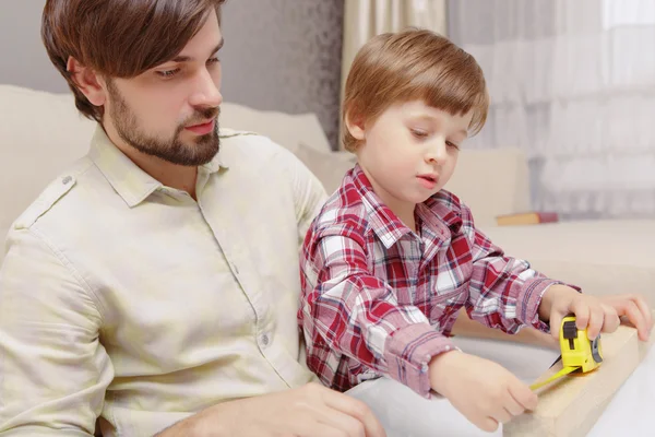 Ojciec i syn z linijką — Zdjęcie stockowe