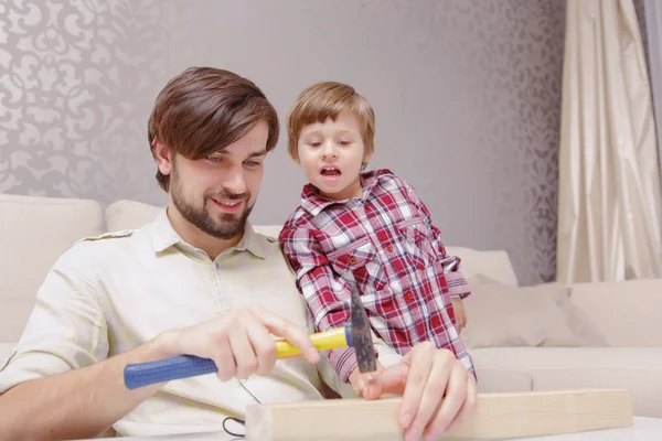 Vater und Sohn setzen Hammer ein — Stockfoto