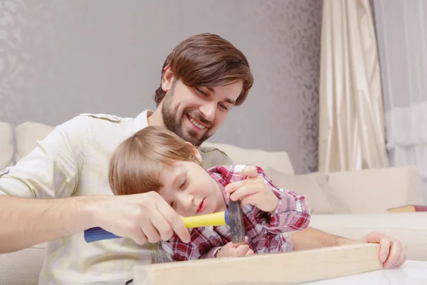 Vater und Sohn setzen Hammer ein — Stockfoto