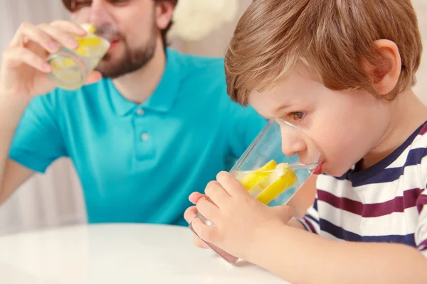 Pai e filho bebem limonada — Fotografia de Stock