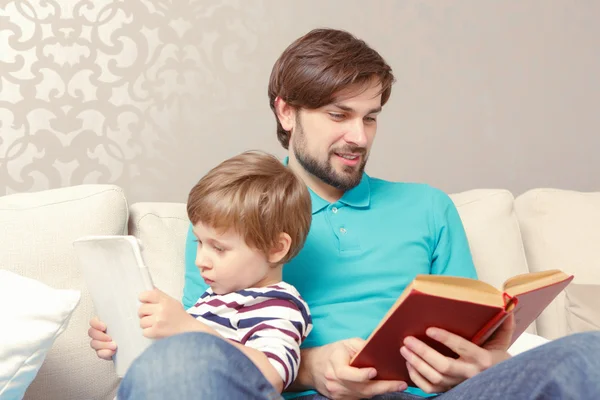 Père et fils lisent un livre ou une tablette — Photo