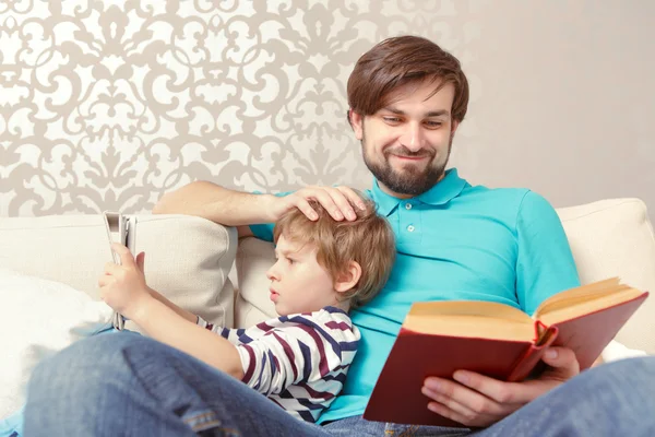 Père et fils lisent un livre ou une tablette — Photo