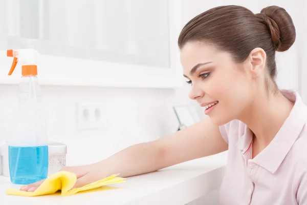 Young pretty female dusting furniture — Stock Photo, Image