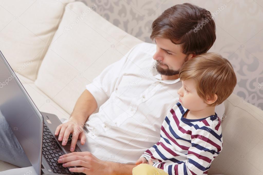 Father and son use computer