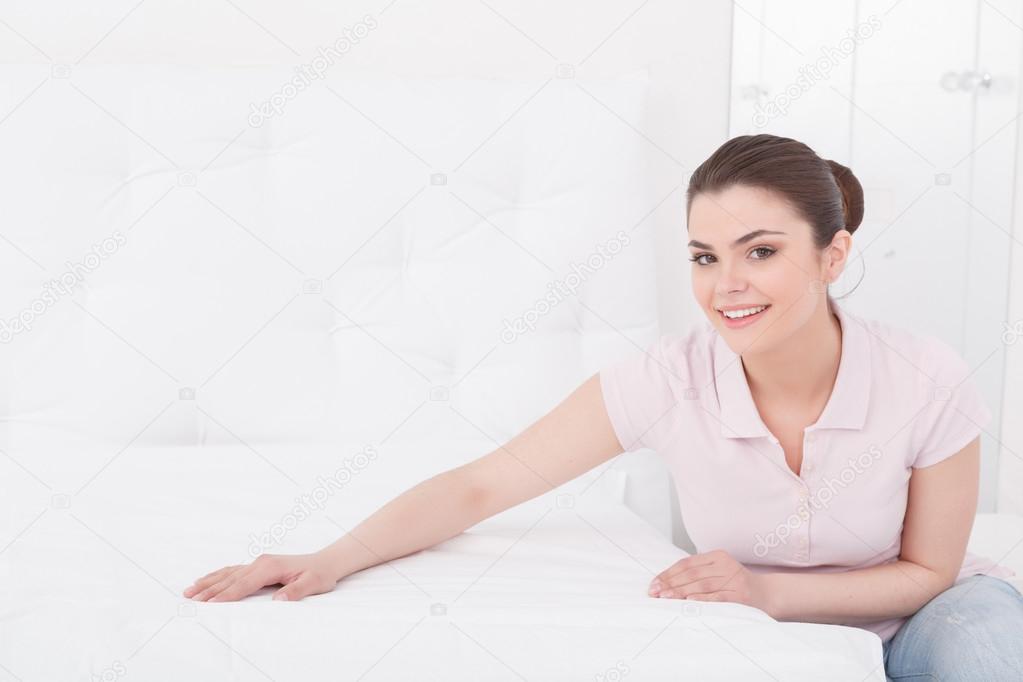 Young beautiful woman making bed
