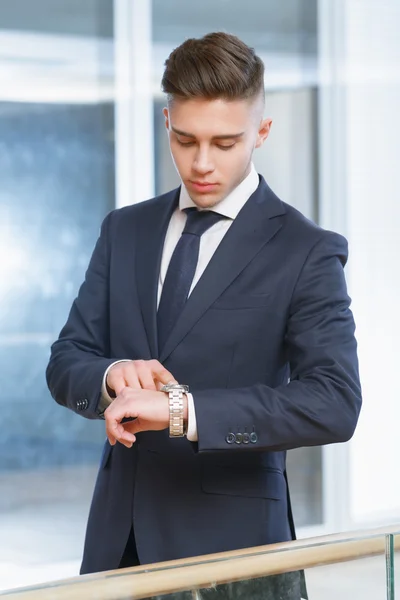 ビジネスマンのオフィスで彼の腕時計を見て — ストック写真