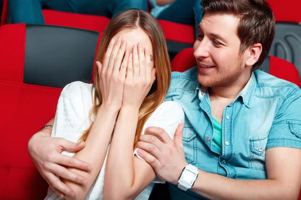 Mulher protegendo os olhos com as mãos no cinema — Fotografia de Stock