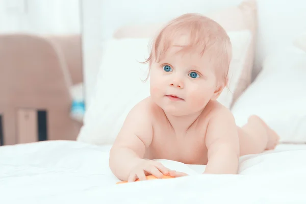 Pequeno bebê deitado na cama e sorrindo — Fotografia de Stock