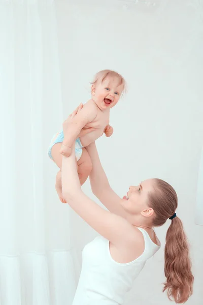 Mutter spielt mit ihrem Kind und wirft das Baby hoch — Stockfoto