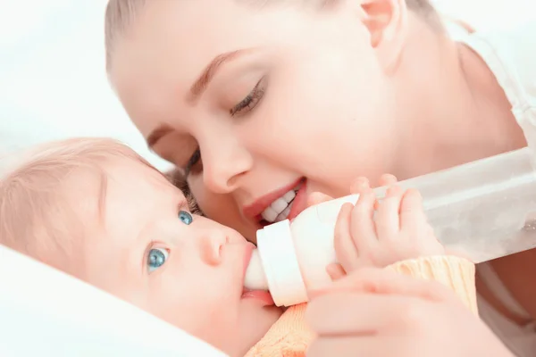 Moeder en haar kleine baby met de fles — Stockfoto