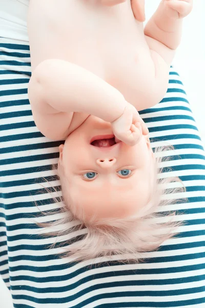 Pequeno bebê pendurado de cabeça para baixo — Fotografia de Stock