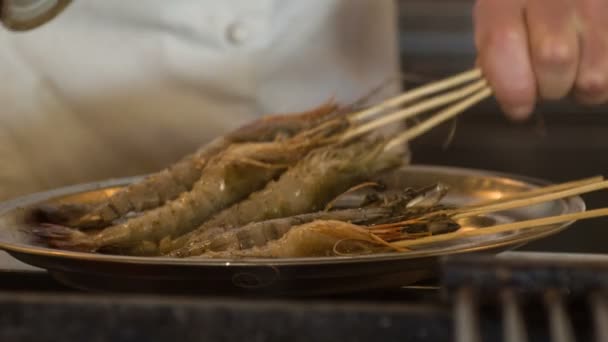 Chef de pie en la cocina del restaurante cerca de la parrilla de fuego convirtiendo pescado — Vídeo de stock