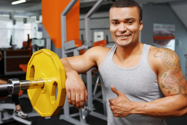 Haltérophile appuyé sur l'haltère dans la salle de gym — Photo