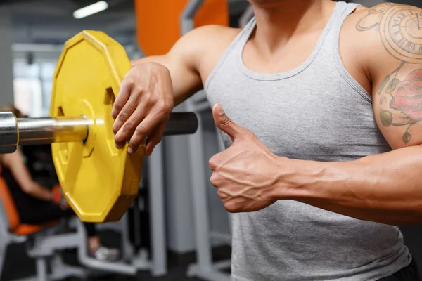 Haltérophile appuyé sur l'haltère dans la salle de gym — Photo