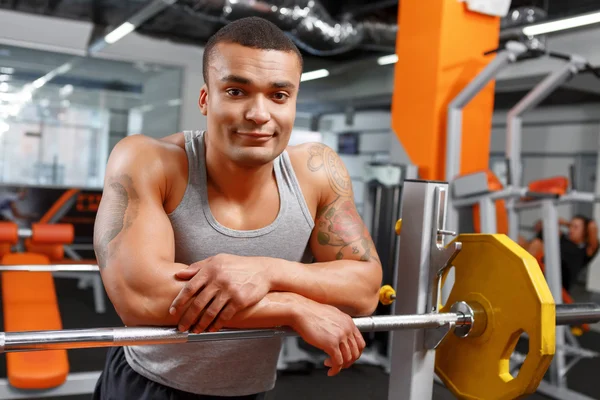 Haltérophile musculaire appuyé sur la barre dans la salle de gym — Photo