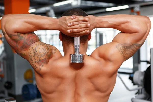 Man holding dumbbells behind his head — Stock Photo, Image