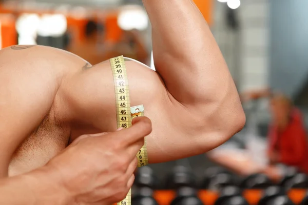 Man meten grootte van zijn biceps — Stockfoto