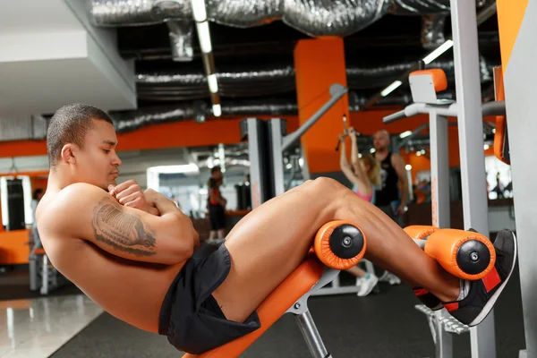 Angenehmer junger Mann macht Bauchkrämpfe im Fitnessstudio — Stockfoto