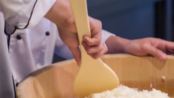Rastreamento tiro de sorrindo chef asiático misturando arroz em tigela de madeira grande — Vídeo de Stock