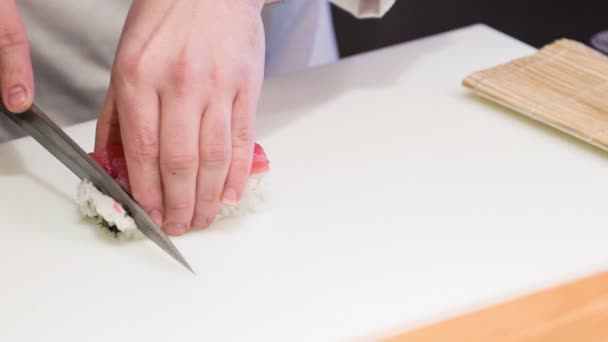 アジアのシェフが食欲をそそる寿司ロールを切る — ストック動画