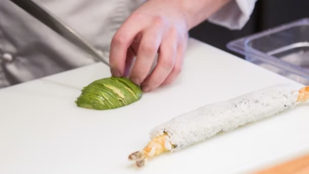 Asian chef cutting avocado for sushi rolls — Stock Video