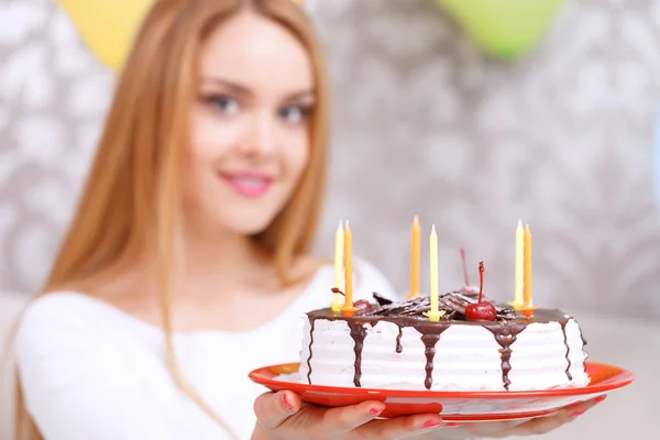 Chica joven con un pastel de cumpleaños y tapa de cono — Foto de Stock