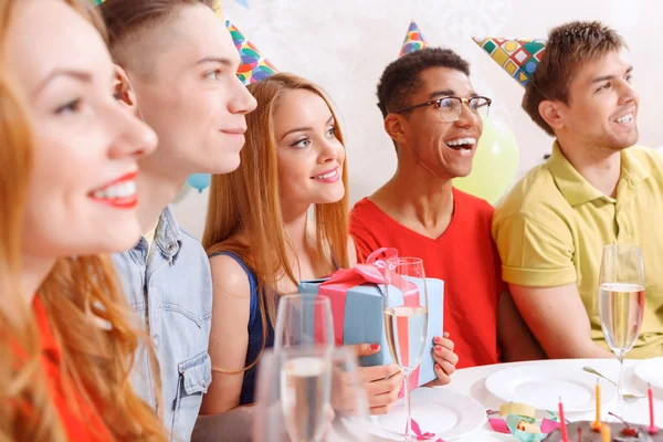 Young people celebrating a birthday sitting at the table