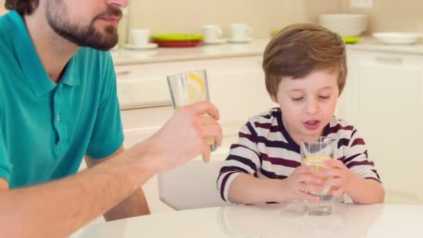 Vader en zoon zit in keuken — Stockvideo