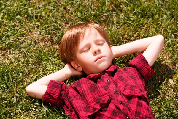 Vue du dessus du petit garçon endormi sur l'herbe — Photo