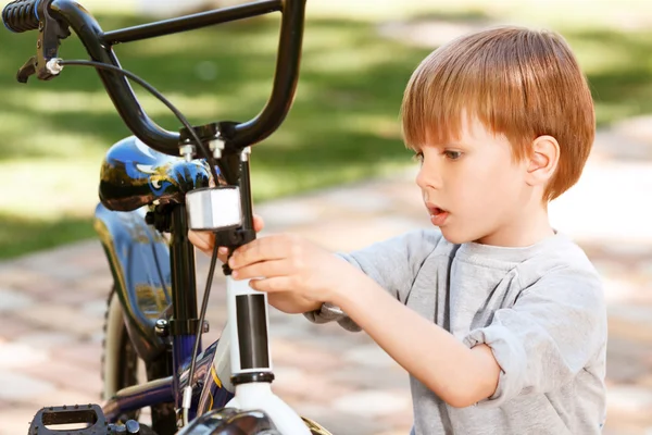 Gros plan du petit garçon réparant son vélo — Photo