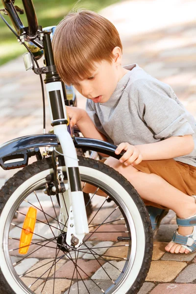 Gros plan du petit garçon réparant son vélo — Photo