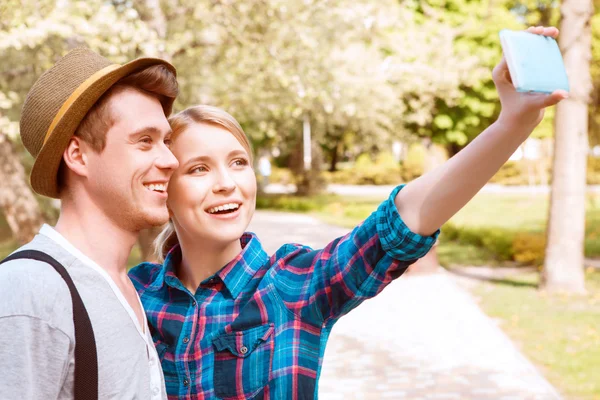 Młoda para robi selfie w parku. — Zdjęcie stockowe