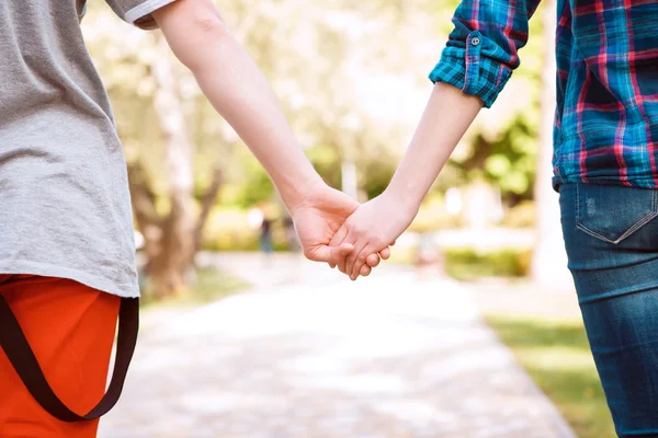 Pareja joven tomados de la mano uno del otro — Foto de Stock