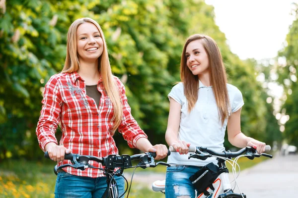 Две красивые девушки рядом с велосипедами — стоковое фото