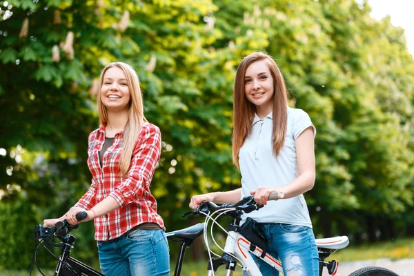 Две красивые девушки рядом с велосипедами — стоковое фото