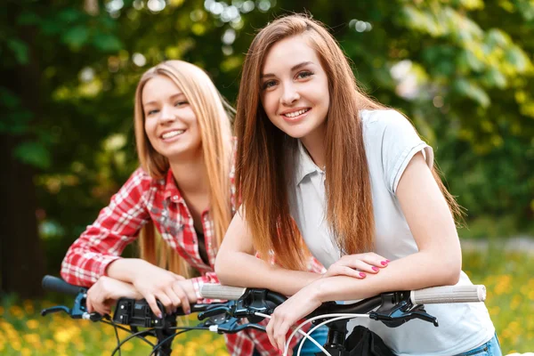 Två vackra flickor nära cyklar — Stockfoto