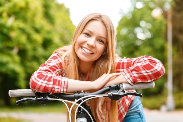 Mujer rubia con su bicicleta — Foto de Stock