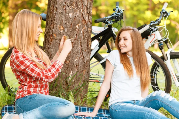 Две девушки на пикнике с велосипедами — стоковое фото