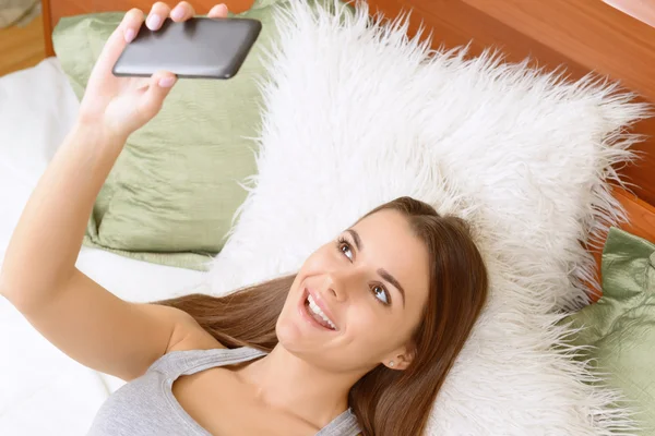 Jonge vrouw skyping op telefoon thuis. — Stockfoto