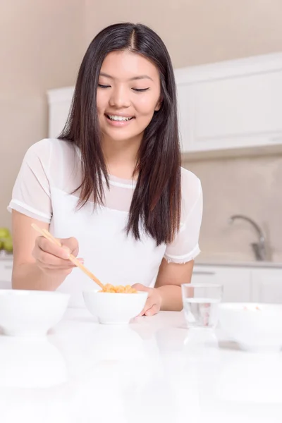 Nice Asian girl eating with sticks — Stock Photo, Image