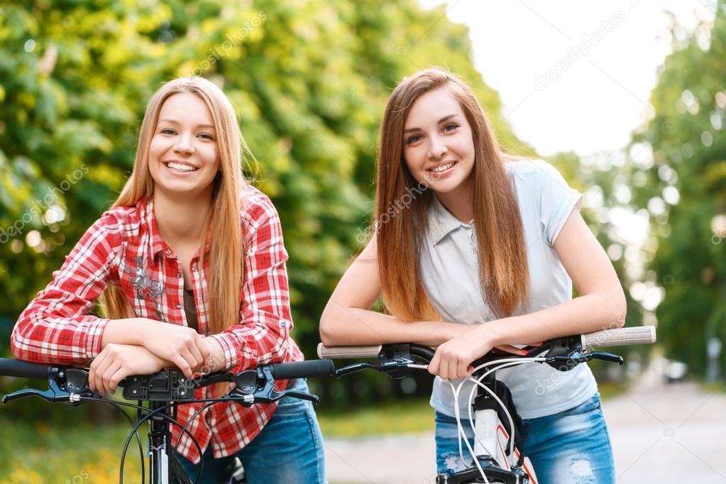 Two beautiful girls near bikes