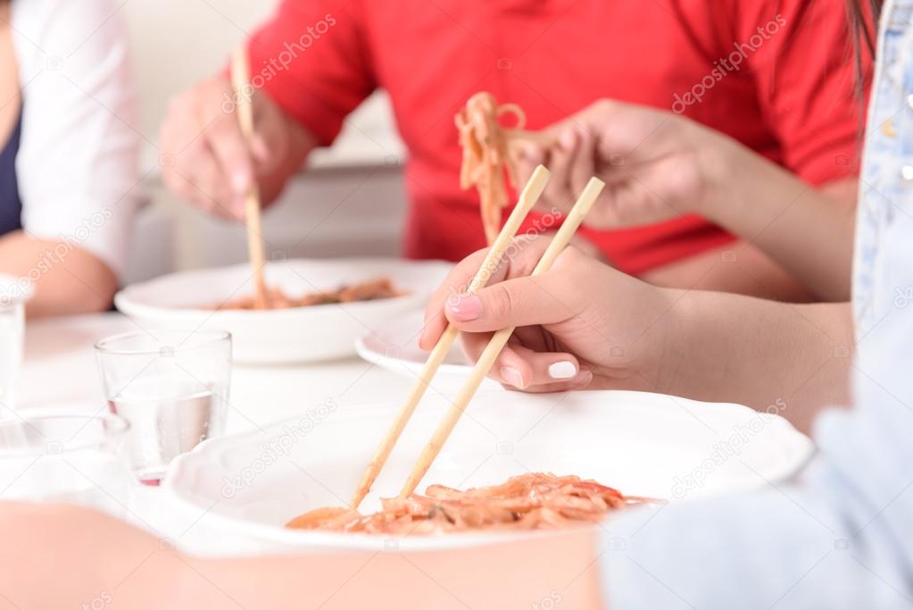 Asians eating with sticks. 