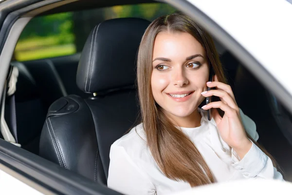 Mujer usando el teléfono móvil en el coche — Foto de Stock