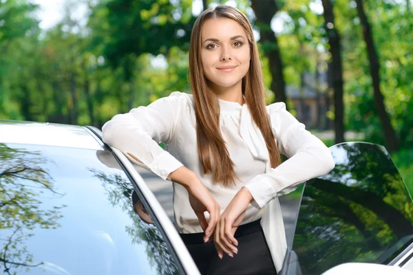 Mladá žena stojící poblíž auto — Stock fotografie