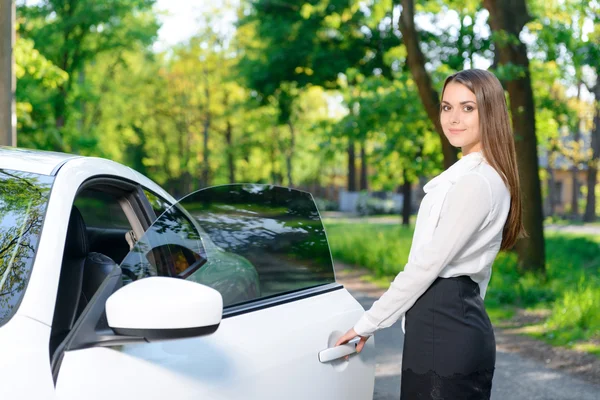 Mujer sonriente abriendo la puerta del coche — Foto de Stock